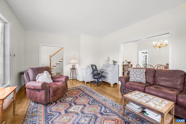 living room with a chandelier, wood finished floors, and stairway