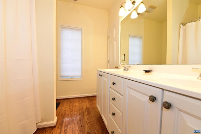 bathroom with baseboards, wood finished floors, and vanity
