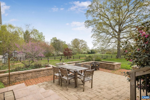 view of patio with fence private yard, outdoor dining space, and an outdoor fire pit