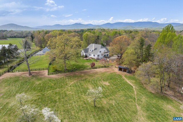 drone / aerial view with a mountain view, a view of trees, and a rural view