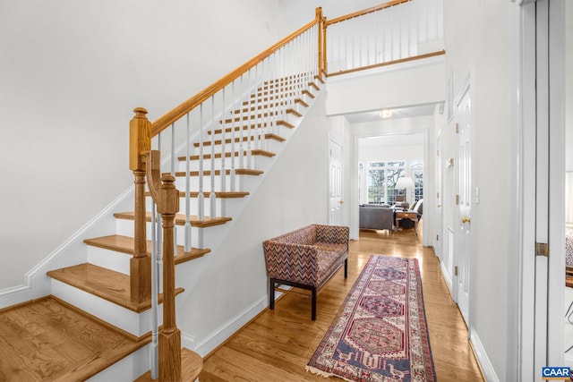 staircase featuring baseboards and wood finished floors