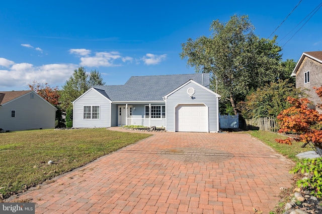 view of front of property with a garage, covered porch, and a front yard