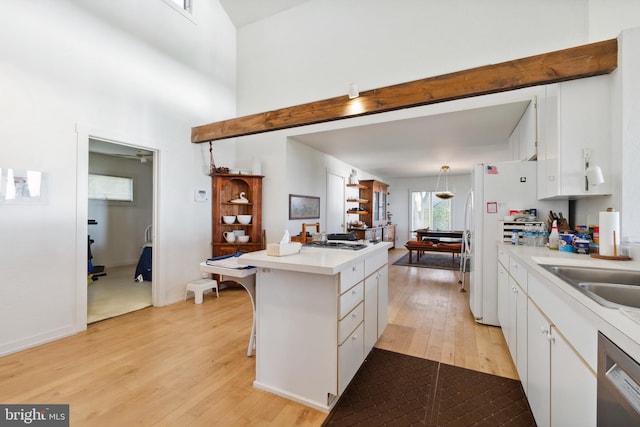 kitchen with stainless steel dishwasher, light wood-type flooring, a kitchen bar, and white cabinetry