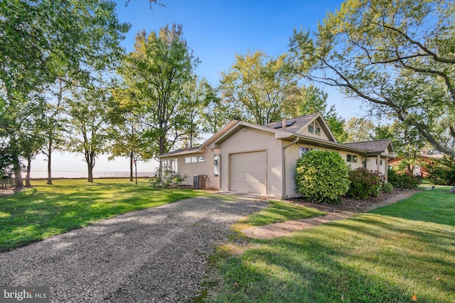 view of side of home with a garage, a lawn, and central AC