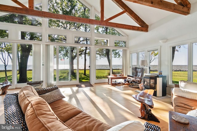 sunroom featuring a water view, a wealth of natural light, and vaulted ceiling with beams