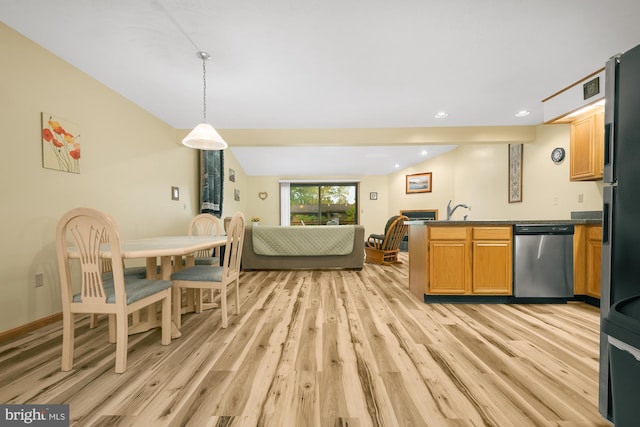 kitchen featuring hanging light fixtures, sink, light hardwood / wood-style flooring, appliances with stainless steel finishes, and dark stone countertops