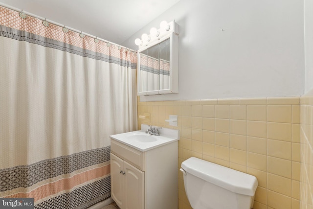 bathroom with tile walls, vanity, and toilet