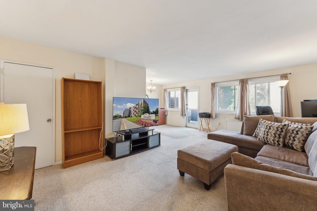 living room featuring light carpet and an inviting chandelier