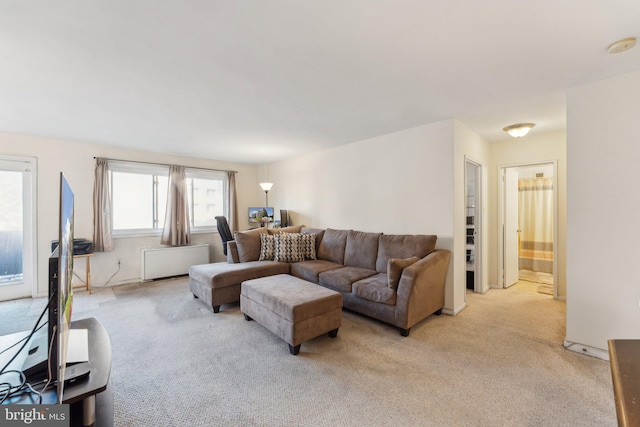 living room featuring radiator heating unit and light colored carpet