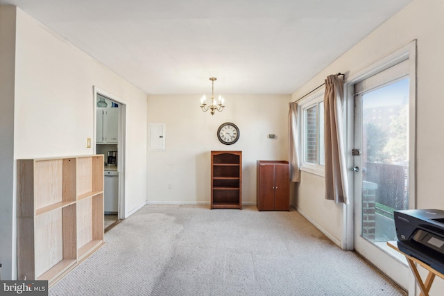 spare room with a chandelier, electric panel, and light colored carpet