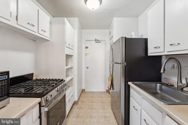 kitchen featuring light tile patterned flooring, white cabinets, stainless steel appliances, and sink