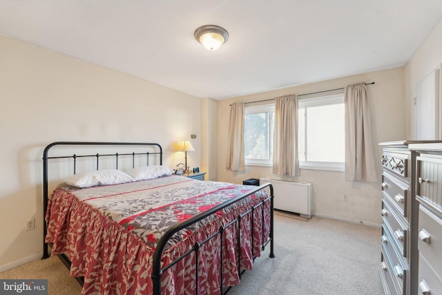 bedroom with radiator and light colored carpet