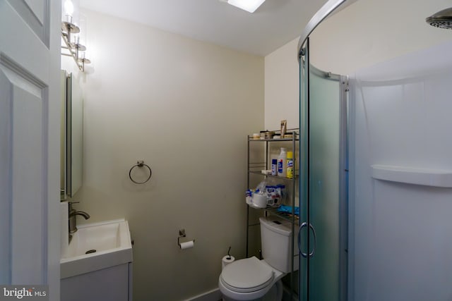 bathroom featuring vanity, toilet, and an enclosed shower