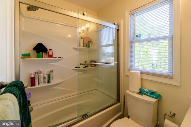 bathroom featuring toilet and combined bath / shower with glass door