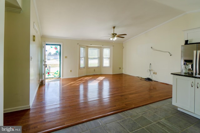 unfurnished living room featuring ceiling fan, ornamental molding, dark hardwood / wood-style flooring, and vaulted ceiling