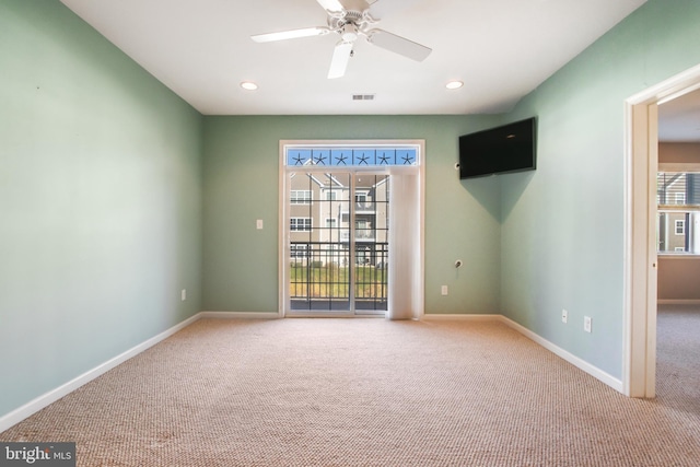 carpeted spare room with ceiling fan