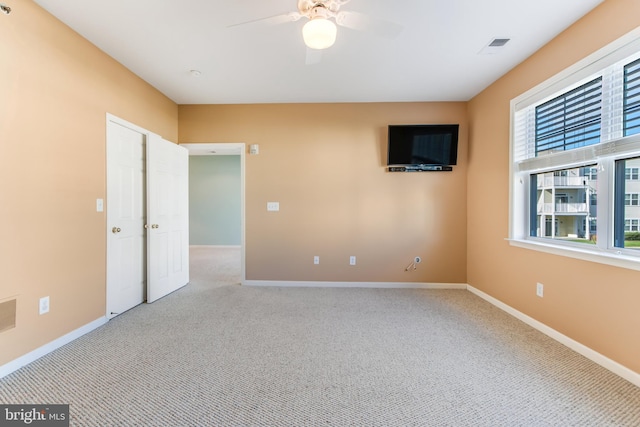 unfurnished room featuring light carpet and ceiling fan