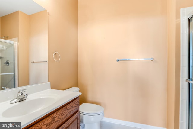 bathroom featuring vanity, walk in shower, and toilet