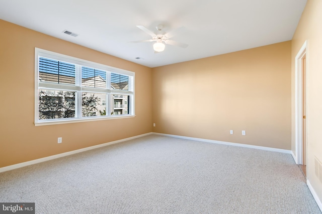 unfurnished room with ceiling fan and carpet