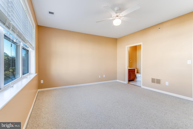 carpeted spare room featuring ceiling fan