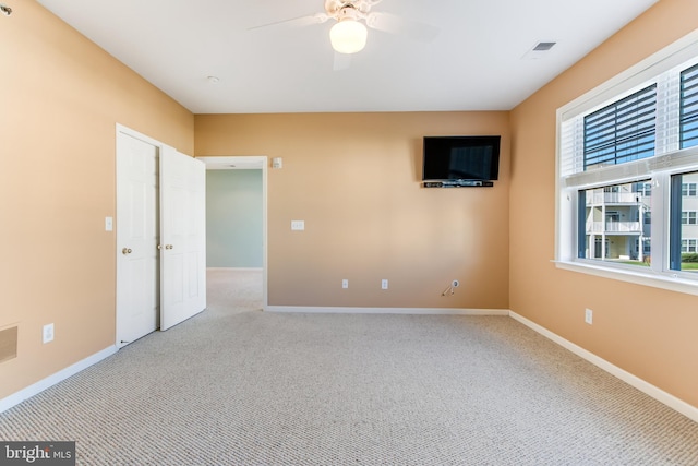 carpeted spare room with ceiling fan