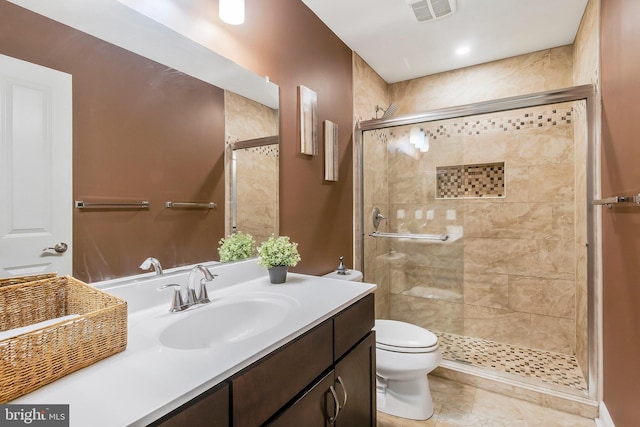 bathroom with tile patterned floors, toilet, vanity, and walk in shower