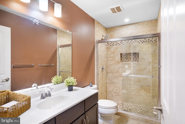 bathroom with tile patterned floors, vanity, toilet, and a shower with door