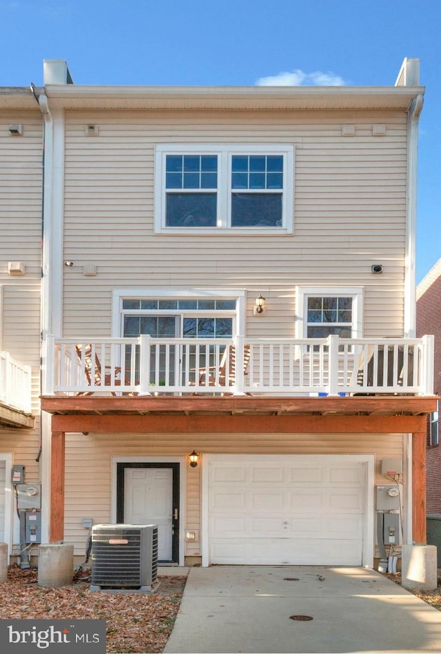 back of property with a balcony, a garage, and cooling unit