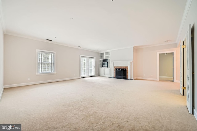 unfurnished living room featuring built in shelves, light colored carpet, a fireplace, and crown molding