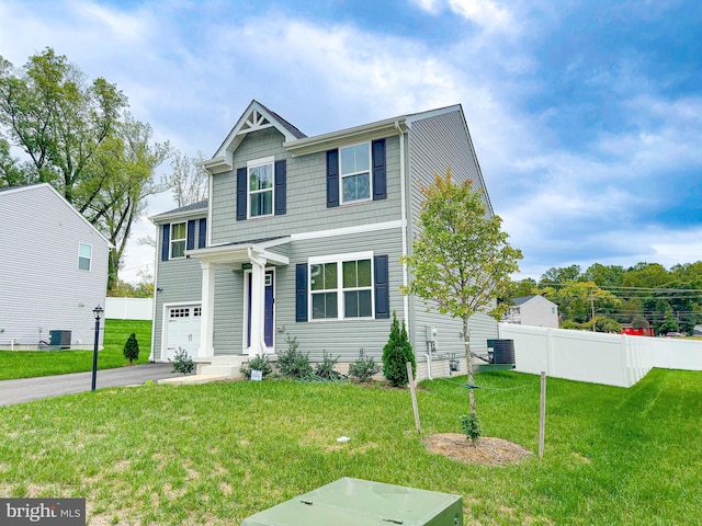 view of front of home featuring central air condition unit, a front yard, and a garage