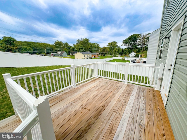 wooden deck featuring a lawn