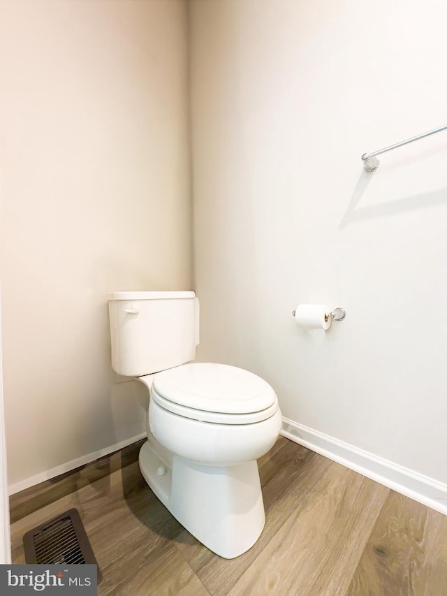 bathroom with hardwood / wood-style floors and toilet