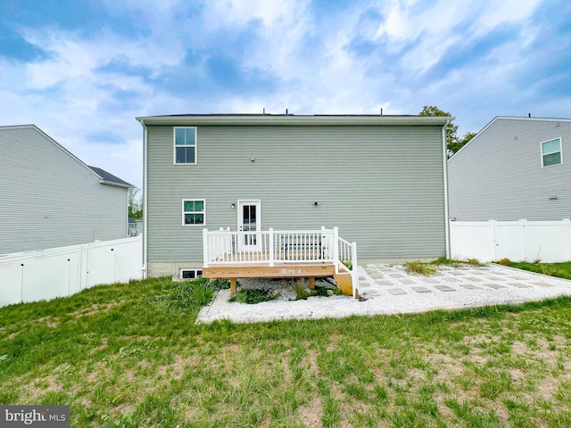 back of property featuring a lawn, a patio area, and a wooden deck