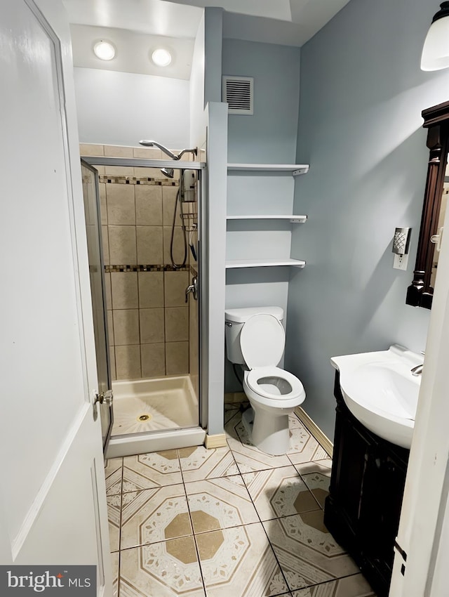 bathroom featuring walk in shower, vanity, toilet, and tile patterned floors