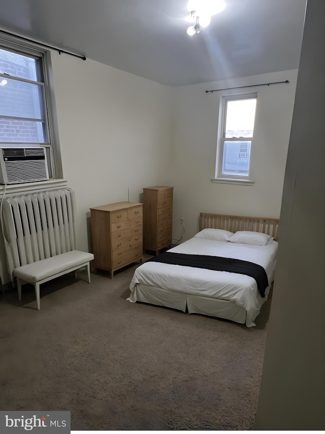 bedroom with cooling unit, radiator heating unit, and carpet flooring