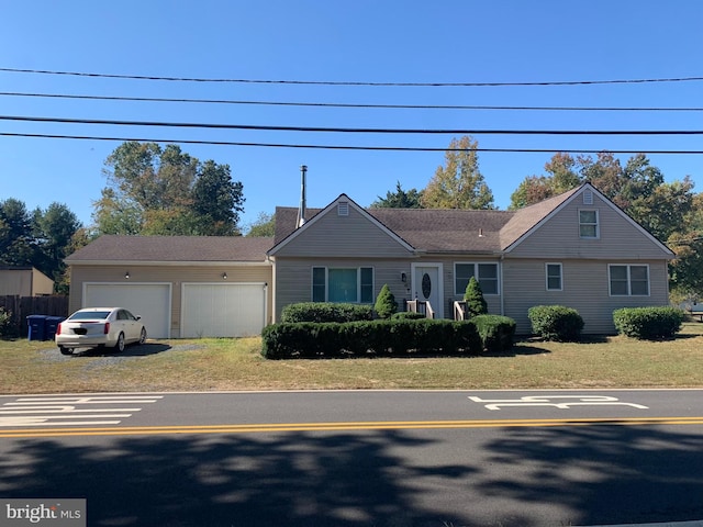 single story home featuring a front lawn and a garage