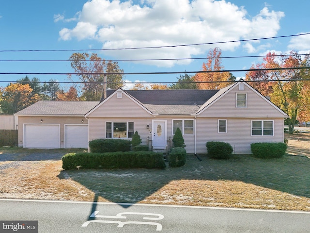 single story home with a garage and a front lawn