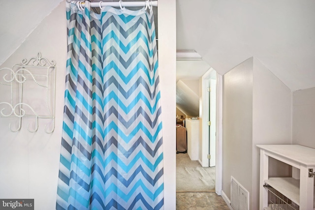 bathroom with vaulted ceiling and curtained shower