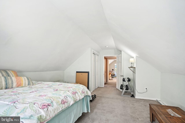 carpeted bedroom with a closet and vaulted ceiling