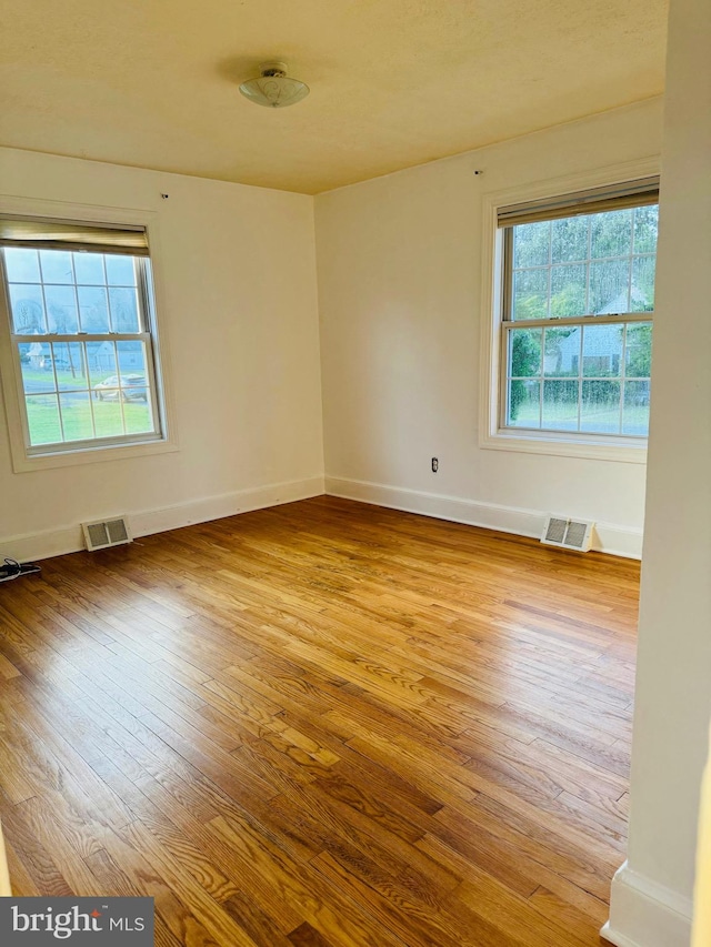 empty room with light hardwood / wood-style flooring