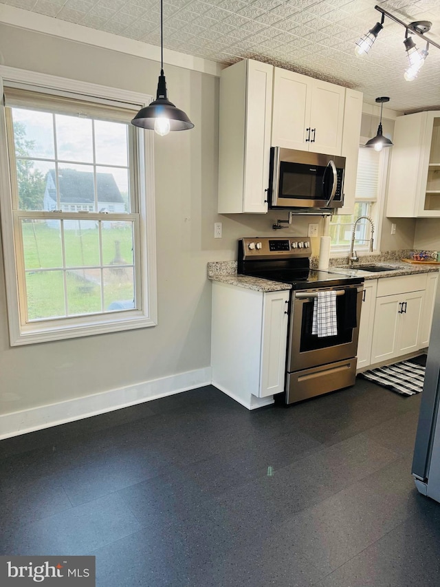 kitchen with stainless steel appliances, white cabinetry, and hanging light fixtures