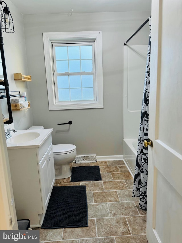 full bathroom featuring vanity, shower / bath combo with shower curtain, and toilet