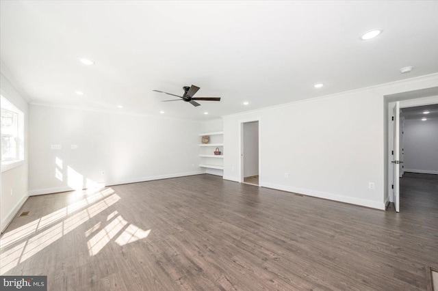 unfurnished living room with built in features, ornamental molding, dark hardwood / wood-style flooring, and ceiling fan