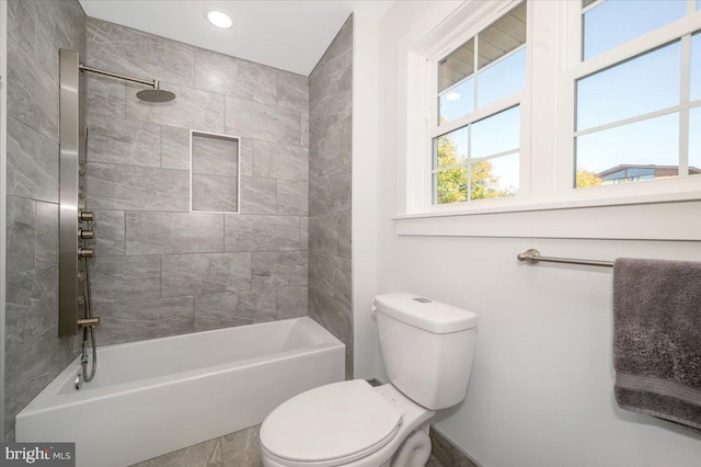 bathroom featuring tiled shower / bath and toilet