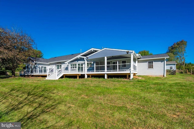 rear view of property featuring a lawn and a wooden deck