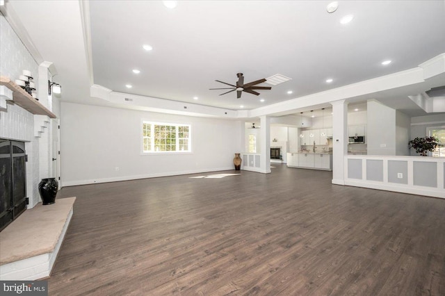 living room featuring a fireplace, dark hardwood / wood-style floors, and ceiling fan