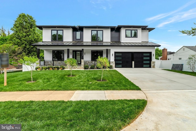 modern farmhouse featuring a front yard, a garage, and a porch