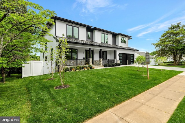 view of front of property featuring a porch, a garage, and a front yard