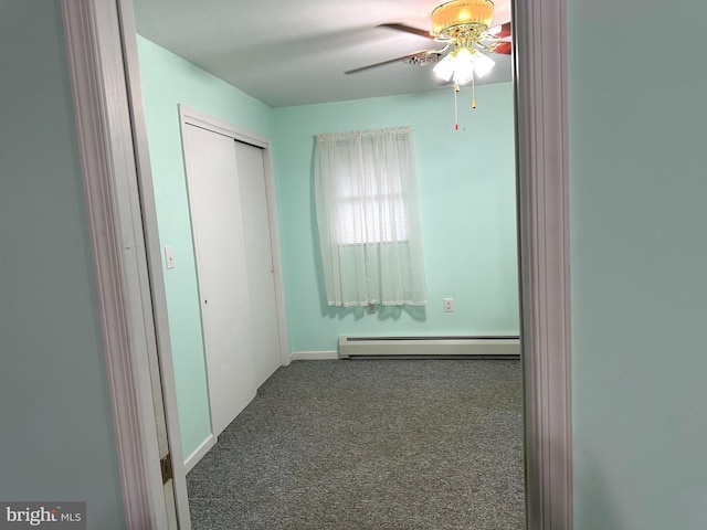 unfurnished bedroom featuring carpet floors, ceiling fan, a closet, and a baseboard heating unit