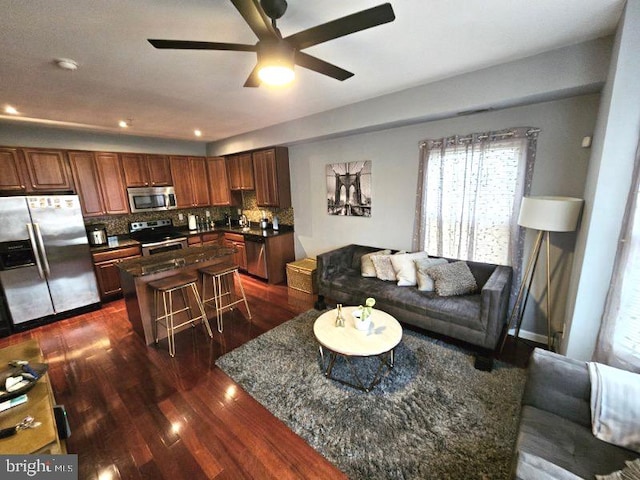 living room featuring ceiling fan, dark wood-type flooring, and sink